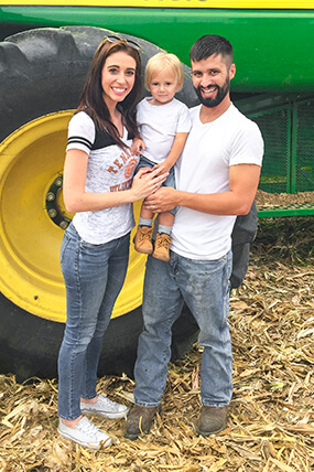 Matt Hostettler and his family in front of a combine